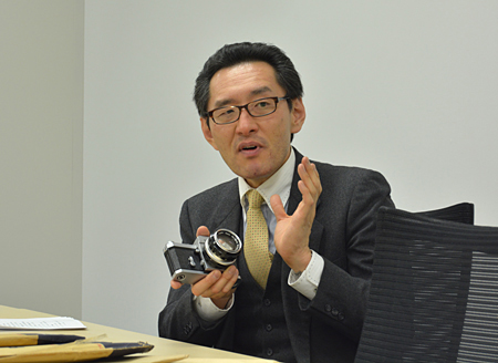 佐藤主幹が手にしているのが1959年発売の「ニコン F」