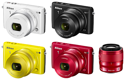 丸みのあるミニマルボディのレンズ交換式アドバンストカメラ「Nikon 1 S2」。「標準パワーズームレンズキット」のホワイト、ブラック、イエローと「ダブルズームキット」のレッド